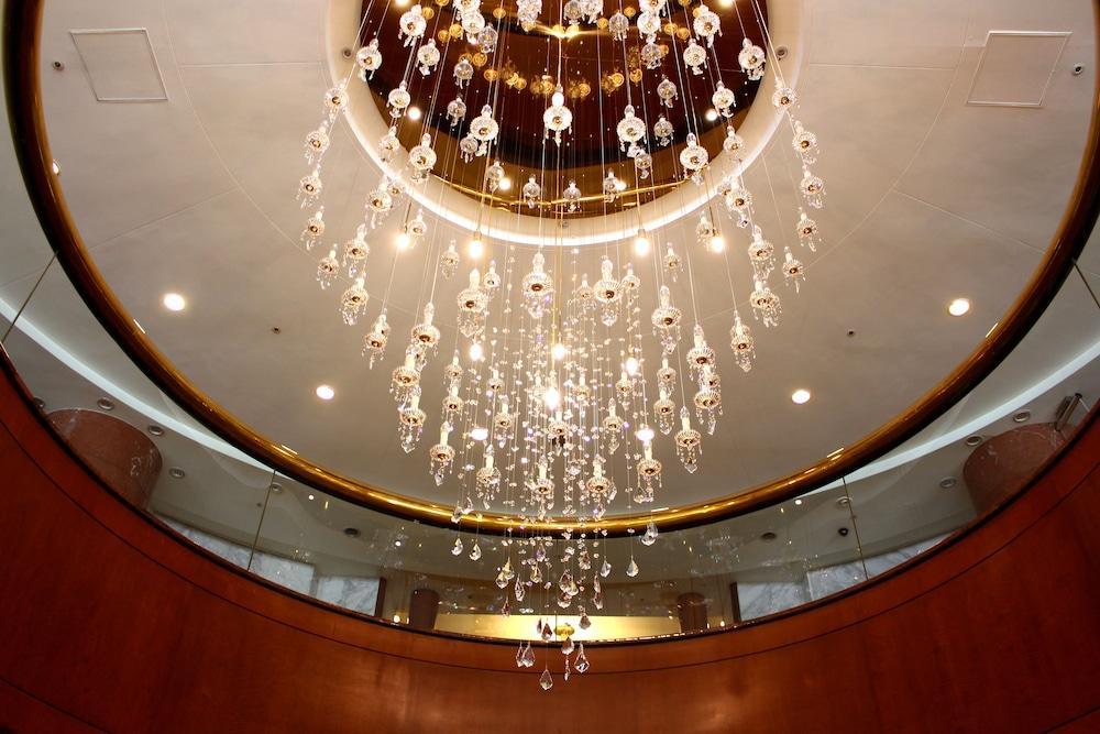 Evergreen Laurel Hotel - Taichung Exterior foto The photo shows an elegant chandelier hanging from a ceiling. The chandelier features numerous hanging crystals that reflect light, creating a sparkling effect. The ceiling itself is circular and designed with a smooth surface, accented by a circular