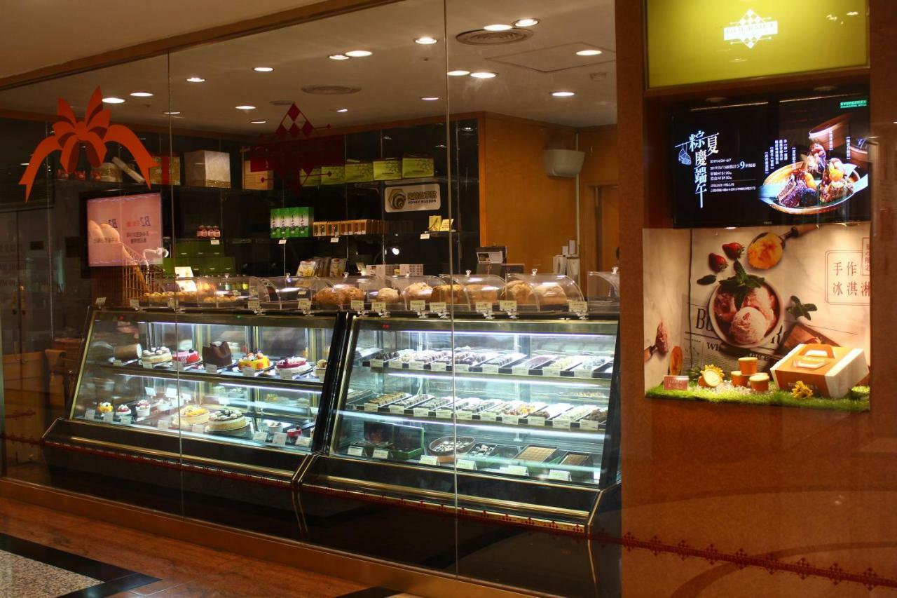 Evergreen Laurel Hotel - Taichung Exterior foto The photo shows a display case in a bakery or dessert shop. The glass case is filled with a variety of pastries, cakes, and desserts arranged neatly. Behind the display, there is a counter with additional items and desserts visible. The walls are dec