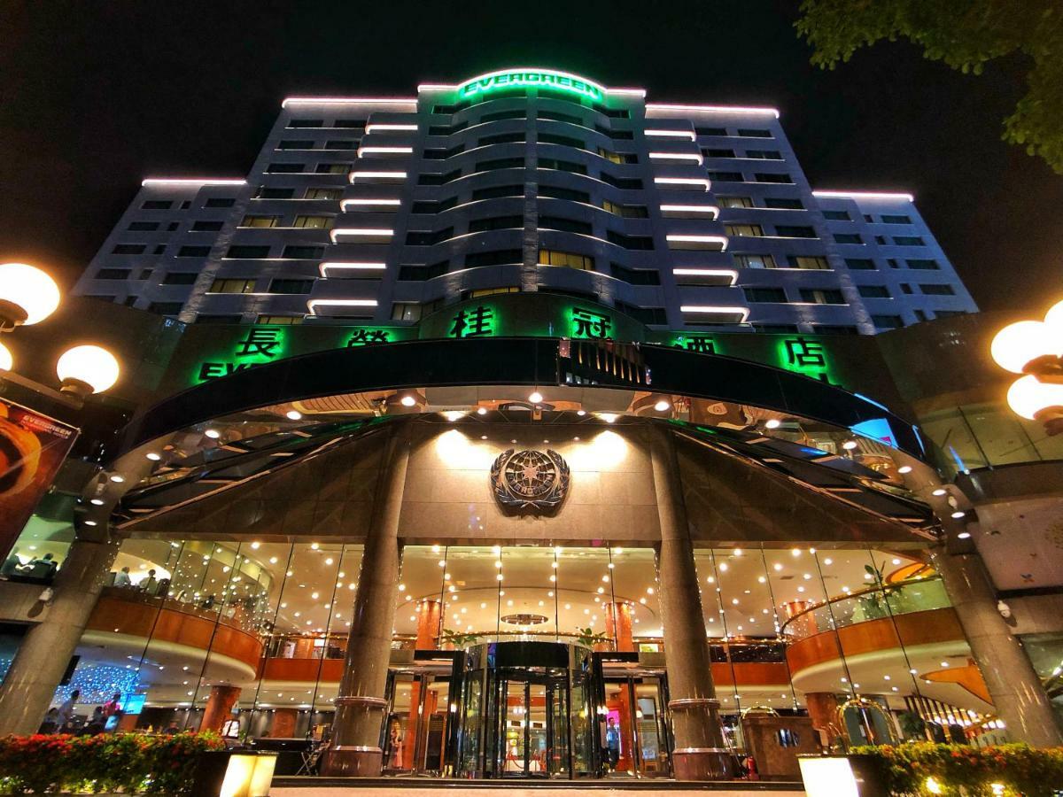 Evergreen Laurel Hotel - Taichung Exterior foto The photo shows a modern building at night, featuring a grand entrance with illuminated signage. The structure has multiple stories with a sleek design, adorned with green lighting that highlights its architectural features. The entrance is spacious 