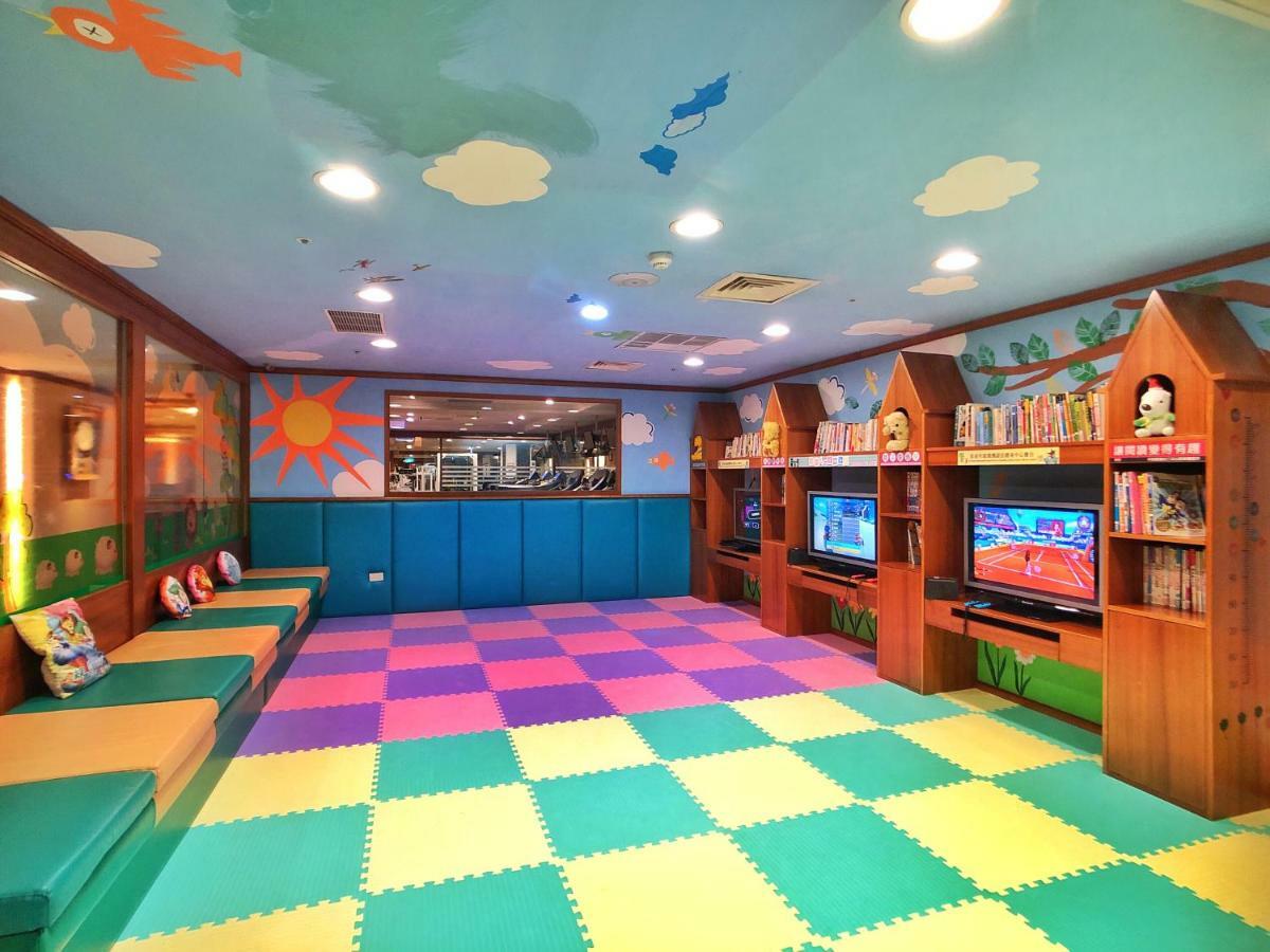 Evergreen Laurel Hotel - Taichung Exterior foto The photo shows a brightly colored children's playroom or activity area. The floor is covered with large colorful tiles in shades of blue, green, yellow, and pink, creating a playful pattern. The walls have cheerful decorations, including sun and clo
