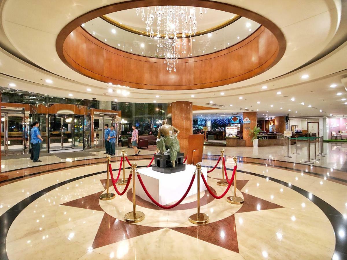 Evergreen Laurel Hotel - Taichung Exterior foto The image shows a spacious lobby area of a building, likely a hotel or an upscale establishment. The design features a circular ceiling with a chandelier hanging from it, creating a bright and elegant ambiance. At the center, there is a statue, likel
