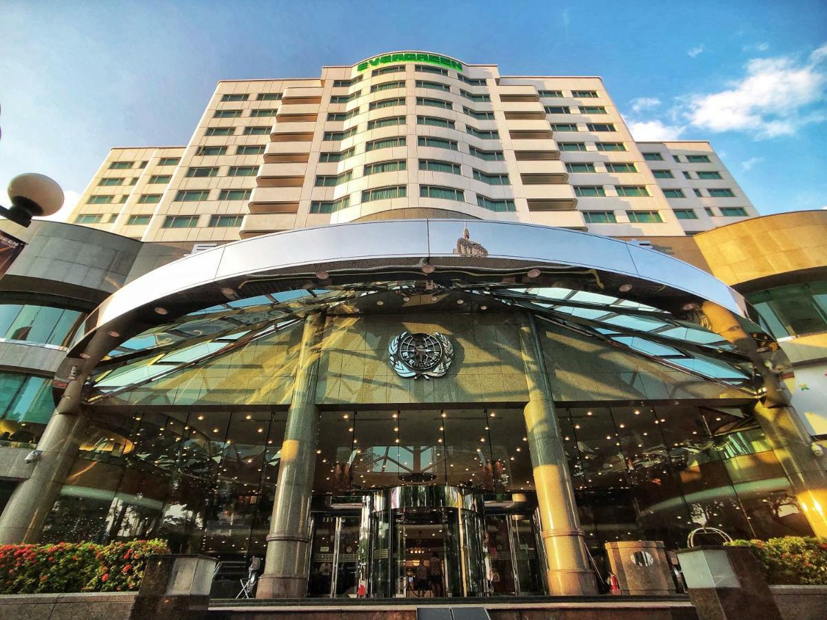 Evergreen Laurel Hotel - Taichung Exterior foto The photo shows the exterior of a modern hotel building. The entrance features a large, glass canopy supported by columns, creating a welcoming area. The facade of the hotel is composed of a mix of glass and concrete, with large windows that suggest 