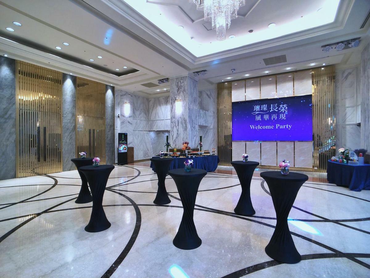 Evergreen Laurel Hotel - Taichung Exterior foto The photo depicts a spacious and elegantly decorated event space, likely set up for a welcome party. The room features polished marble flooring and tall ceilings, giving it a sophisticated atmosphere. In the center, several round tables with black ta